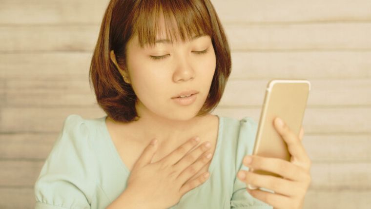胸に手を当てる女性