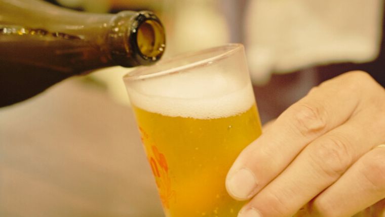 手酌でビールを飲む女性