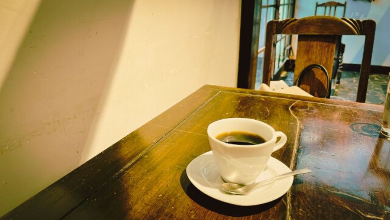 喫茶店の木のテーブルとコーヒー
